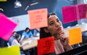 Leader looking at post-its in a wall